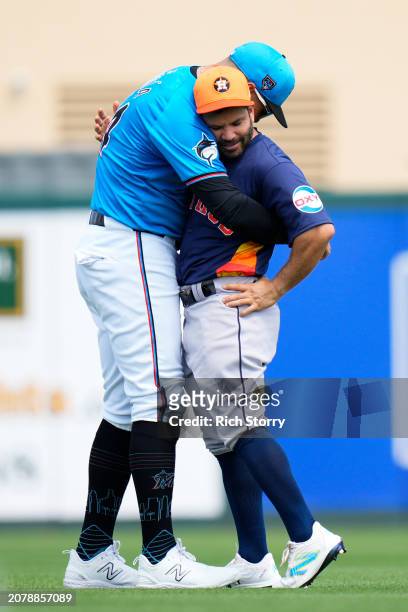 Avisail Garcia of the Miami Marlins and Jose Altuve of the Houston Astros embrace prior to a spring training game at Roger Dean Stadium on March 12,...