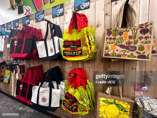 Variety of burlap and fabric reusable tote bags at Trader Joes supermarket, Queens, New York.