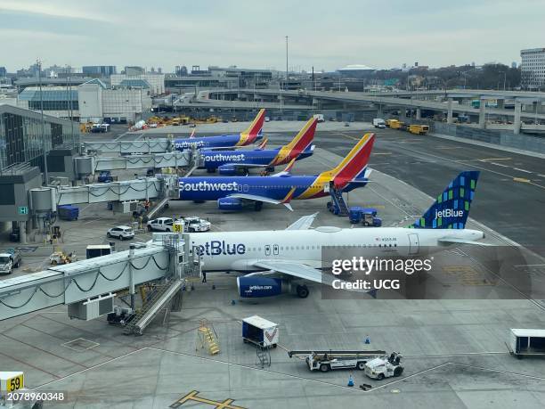 JetBlue and Southwest airplanes at Gate, LaGuardia Airport with view of Flushing Meadow park in background, Queens, New York.