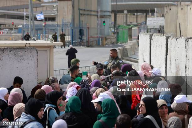 Members of the Israeli security forces man the Qalandia checkpoint in the occupied West Bank, as Palestinians wait to cross into Jerusalem to take...