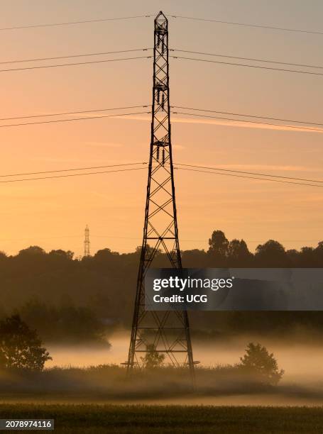 Electricity pylons and spectacular pre-dawn sky in Lower Radley, misty dawn.