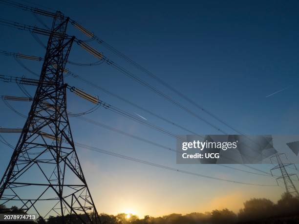 Immense electricity pylons in Kennington, South Oxford at sunrise.