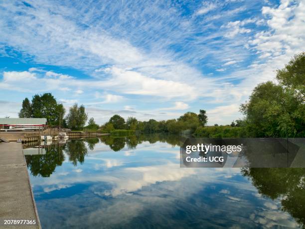Dramatic sky and reflections in the waters of the Thames by Radley Boathouse.