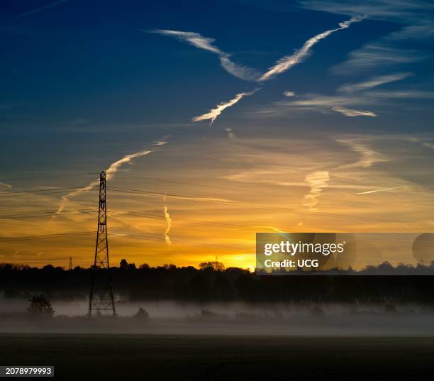 Electricity pylons and spectacular pre-dawn sky in Lower Radley, misty dawn.