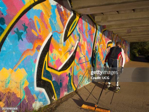 Bizarre roller-blading sweeper passes under Donnington bridge by the Thames at Oxford.