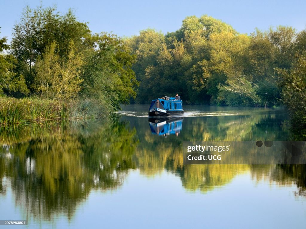 Houseboat cruises past Radley Boathouse by the Thames