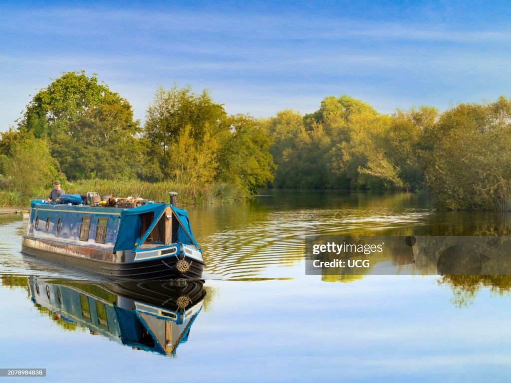 Houseboat cruises past Radley Boathouse by the Thames