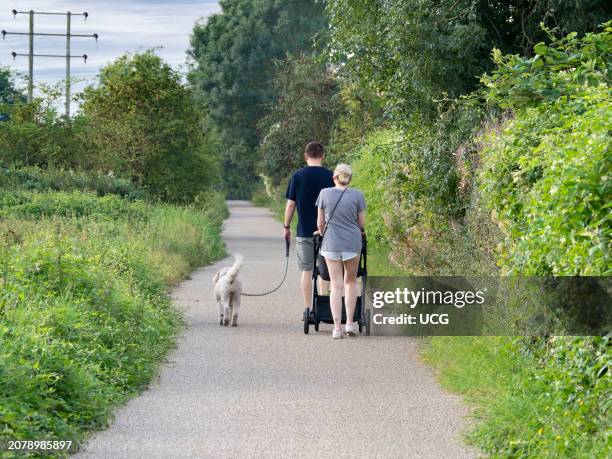 Dog walking family on Kennington Meadows, Oxfordshire.