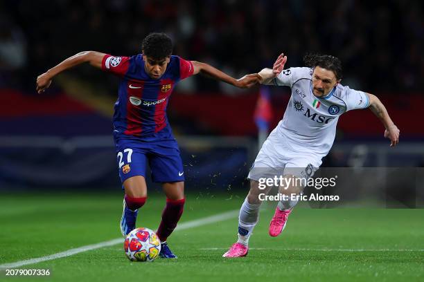 Lamine Yamal of FC Barcelona runs with the ball whilst under pressure from Mario Rui of SSC Napoli during the UEFA Champions League 2023/24 round of...
