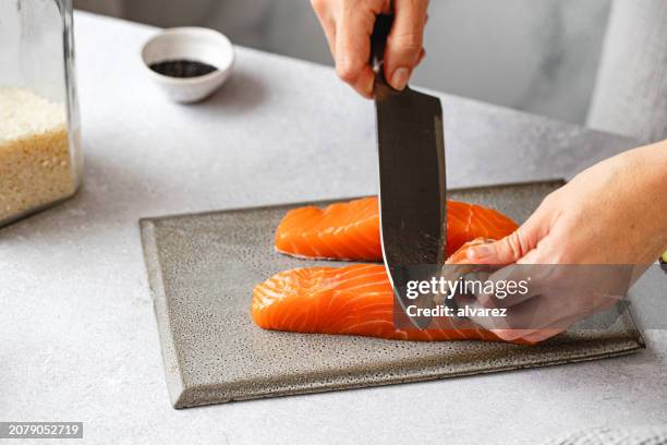 primo piano dello chef che taglia il pesce salmone in cucina - filetto foto e immagini stock