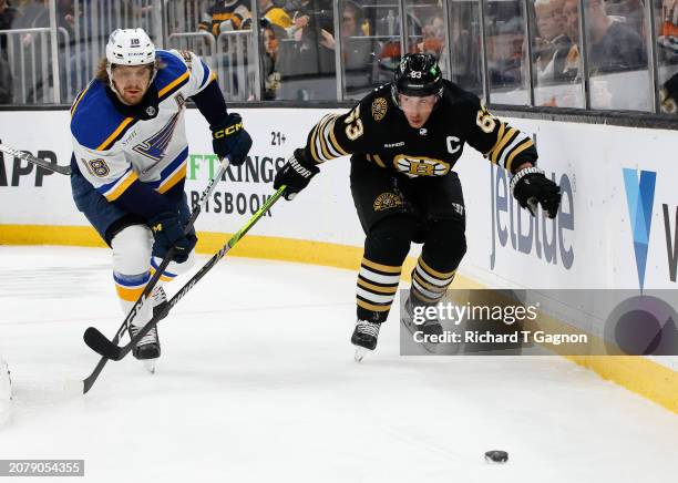 Brad Marchand of the Boston Bruins is checked by Robert Thomas of the St. Louis Blues during the first period at the TD Garden on March 11, 2024 in...