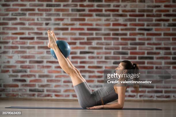 woman exercising pilates using ball at health club - yoga ball work 個照片及圖片檔