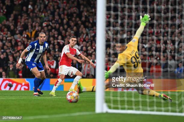 Leandro Trossard of Arsenal scores his team's first goal past Diego Costa of FC Porto during the UEFA Champions League 2023/24 round of 16 second leg...
