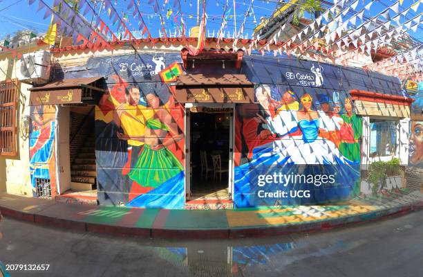 Cartagena, Colombia, A house of the neighborhood Getsemani painted on its facade with colors of the typical costumes of the Colombian Caribbean is...