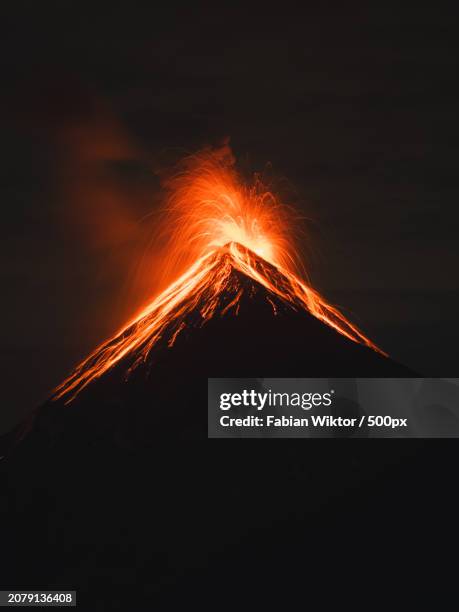 low angle view of illuminated mountain against sky at night - volcanic activity fotografías e imágenes de stock