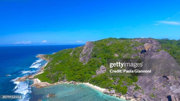 anse source d'argent beach in la digue, seychelles. aerial view of tropical coastline on a sunny day - couple argent stockfoto's en -beelden