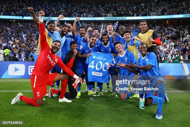 The players of Al Hilal pose for a photo at full-time whilst holding a match shirt to celebrate the 400th appearance for Yasser Al-Shahrani of Al...