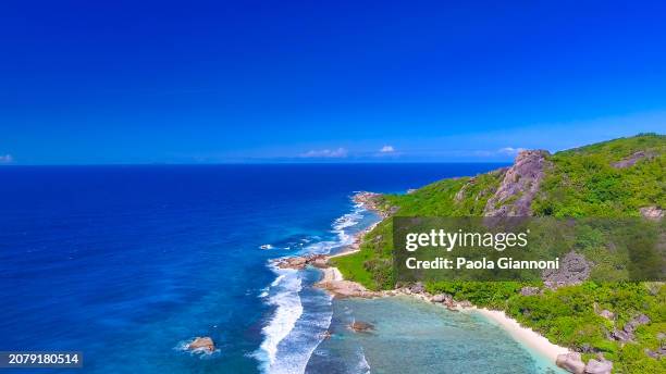 anse source d'argent beach in la digue, seychelles. aerial view of tropical coastline on a sunny day - couple argent stockfoto's en -beelden