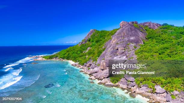 anse source d'argent beach in la digue, seychelles. aerial view of tropical coastline on a sunny day - couple argent stockfoto's en -beelden