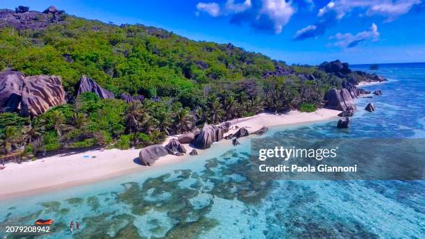 anse source d'argent beach in la digue, seychelles. aerial view of tropical coastline on a sunny day - couple argent stock-fotos und bilder