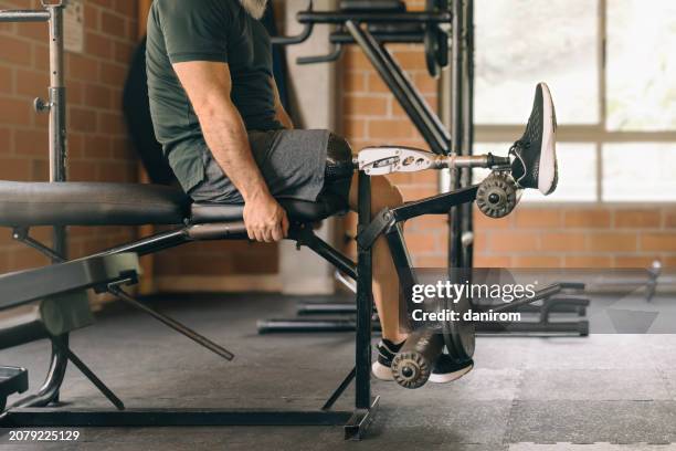 close-up of a man's prosthetic leg at the gym, with his face not visible, as he exercises. - recovery position stock pictures, royalty-free photos & images