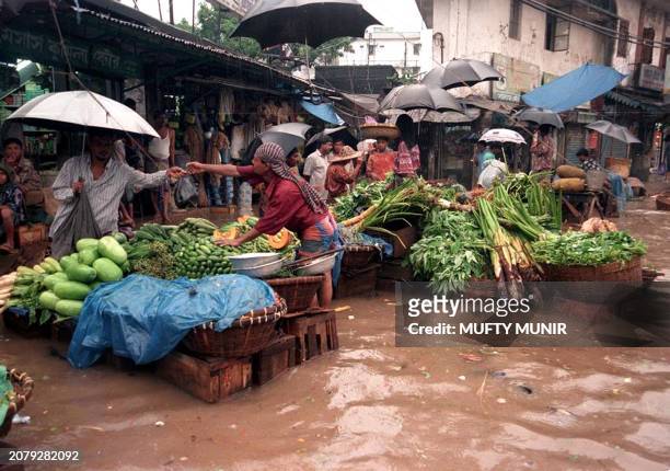 Man shops for produce at a makeshift vegetable market in Dhaka's Shantinagar area, 11 July 1999, as continued rains battered most parts of Bangladesh...