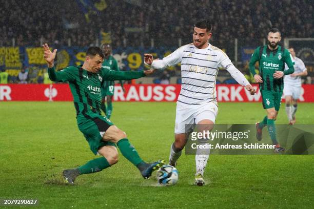 Fabio Di Michele Sanchez of 1. FC Saarbruecken is challenged by Stefan Lainer of Borussia Mönchengladbach during the DFB cup quarterfinal match...
