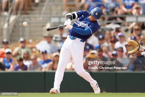 Shohei Ohtani of the Los Angeles Dodgers hits a single against the San Francisco Giants during the first inning of the MLB spring game at Camelback...