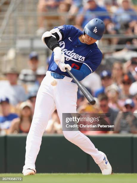 Shohei Ohtani of the Los Angeles Dodgers hits a single against the San Francisco Giants during the first inning of the MLB spring game at Camelback...