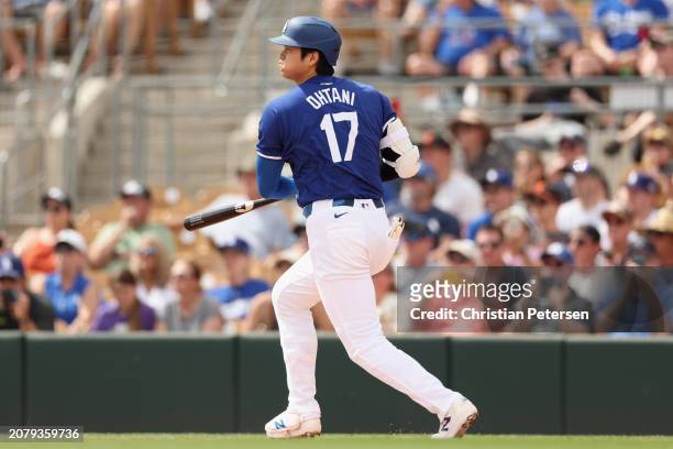 Shohei Ohtani of the Los Angeles Dodgers hits a single against the San Francisco Giants during the first inning of the MLB spring game at Camelback...
