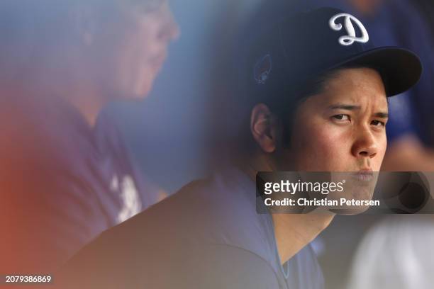 Shohei Ohtani of the Los Angeles Dodgers watches from the dugout during the fourth inning of the MLB spring game against the San Francisco Giants at...