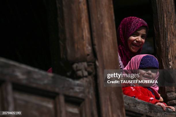 Children look on as Muslim devotees offer first Friday prayers of the Islamic holy month of Ramadan at the Shah-i-Hamdan shrine in downtown Srinagar...