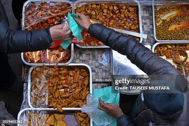 People buy pickles on a roadside stall during the first Friday of the Islamic holy month of Ramadan at the Shah-i-Hamdan shrine in downtown Srinagar...