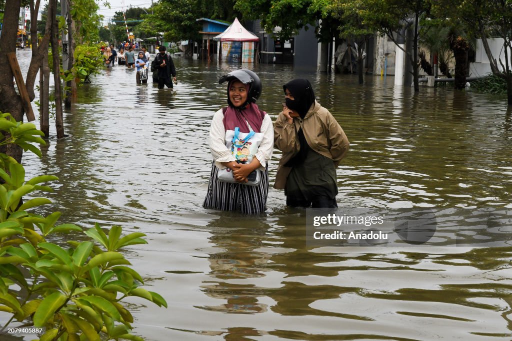 Flooding that submerged the coastal road cause residents to stop and ...