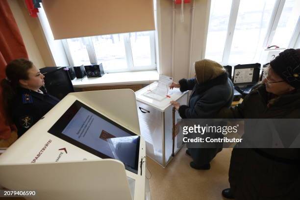 An elderly woman holds her ballot while visiting the polling station, on March 15, 2024 in Moscow, Russia. Russian President Vladimir Putin is...