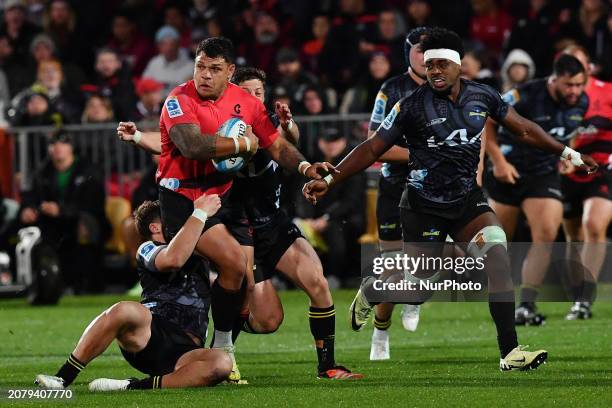 Levi Aumua of the Crusaders is being tackled by the Hurricanes' defense during the round four Super Rugby Pacific match between the Crusaders and the...