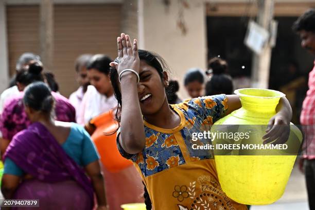 Girl carries a water pot after filling for free from a municipal tanker amidst the ongoing water crisis in Bengaluru on March 15, 2024.