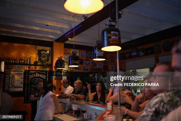 People enjoy a drink at a bar at the old town Willemstad, Curacao, in the Dutch Caribbean, on March 14, 2024.