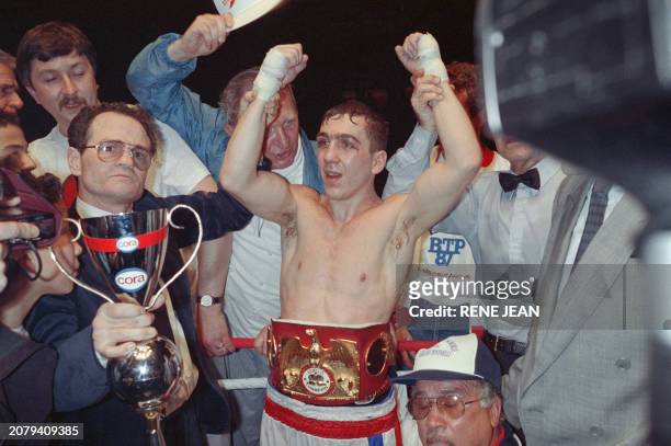French boxer Fabrice Benichou celebrates on March 10, 1989 with friends holding the world cup after fighting Jose Sanabria from Venezuela during the...
