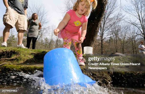Four-year-old Ceara Tyner of Saratoga Springs loses control of her bucket as she releases a brown trout during the annual fish stocking at Geyser...