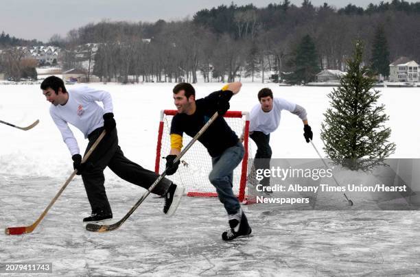 The Sleasman family and friends play ice hockey an annual winter holiday event on a cleared spot behind their grandparents home of 40 years on...