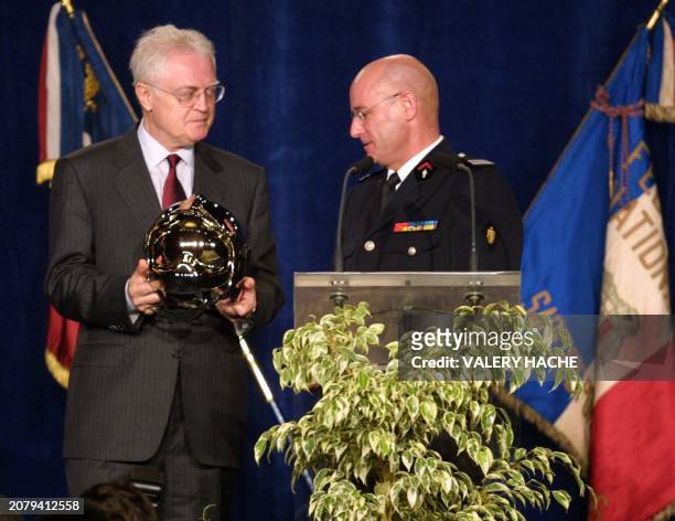 Le Premier ministre Lionel Jospin reçoit en cadeau, des mains du colonel Daniel Ory, un casque de sapeur pompier, le 06 octobre 2001 au centre...