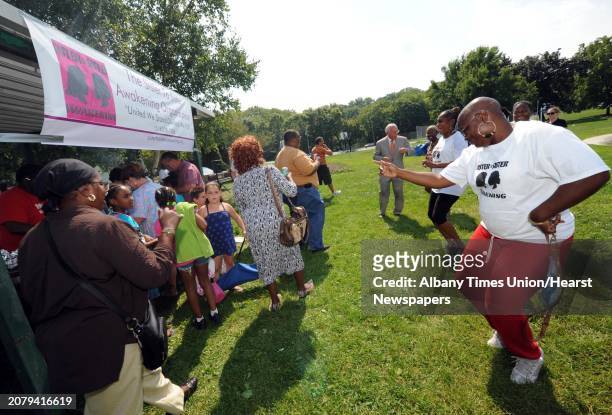 Ri-na Yarmeto, right, joins others in dance during the 2nd Annual Remembering The Fallen Stars community picnic at Krank Park in Albany, NY Saturday...