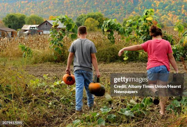 Twelve-year-old Casey Lizza, right, and her 16-year-old brother Peter Lizza pick pumpkins at Pumpkin Pete's on Route 30 in Schoharie, NY Friday Oct....