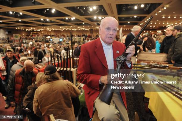 Show board of directors member Doug Roberts holds a 1862 Sharps single shot military rifle during the New York State Arms Collectors Show at the...