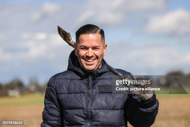 March 2024, North Rhine-Westphalia, Bergheim: Treasure hunter Carsten Konze walks across a field with a spade near Fliesenden . Photo: Oliver Berg/dpa