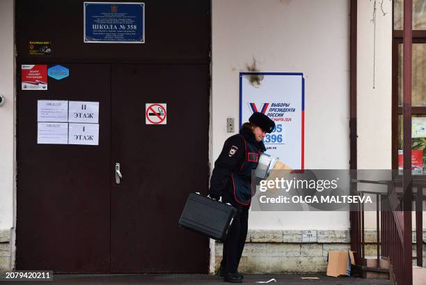 Police secures evidence after a Molotov cocktail was thrown at a school being used as a polling station in Saint Petersburg on March 15 the first...