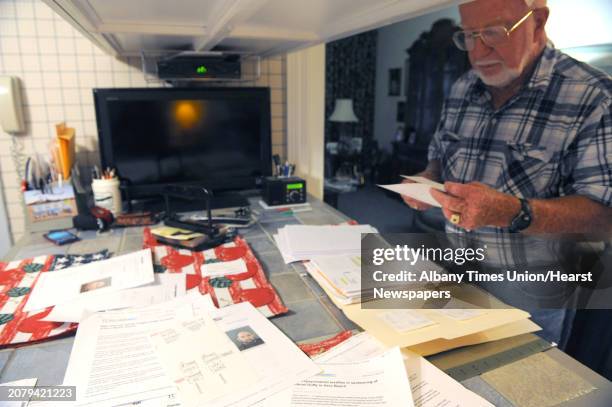 Retiree Daniel Duffy looks over paper work he has received mostly bills for another Daniel J. Duffy using their address on Thursday Sept. 12, 2013 in...