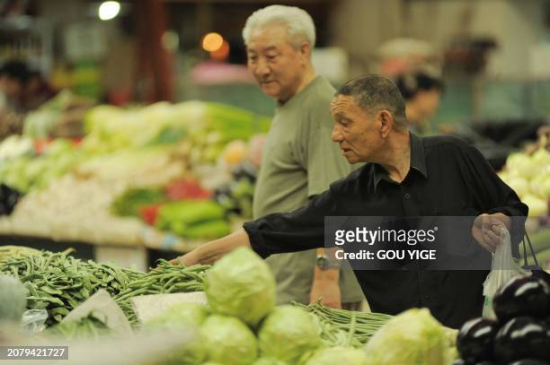 China-economy-inflation-drought,FOCUS by Fran Wang An elderly Chinese man buys vegetables at a market in Beijing on June 1, 2011. China's consumer...