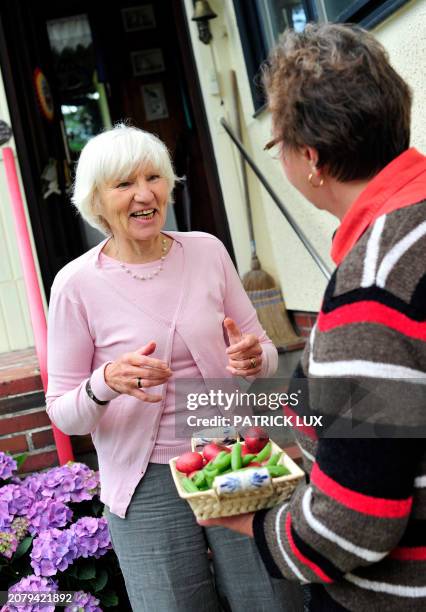 Heidemarie Schwermer receives fresh red potatoes and green beans from her friend Edelmut Voskamp who has homegrown the vegetables in her own garden...